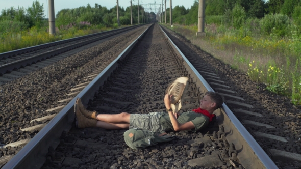 Boy Lying on Train Rails