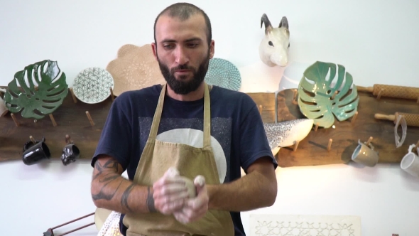 Potter Kneads a Clay in the Light Stylish Potter Working Space