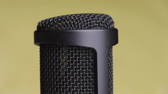 Studio Condenser Microphone Rotates on Yellow Background with Place for Text