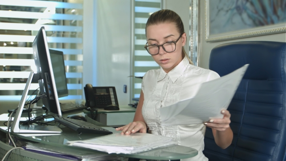 Hard Working Businesswoman with Laptop and Paperwork