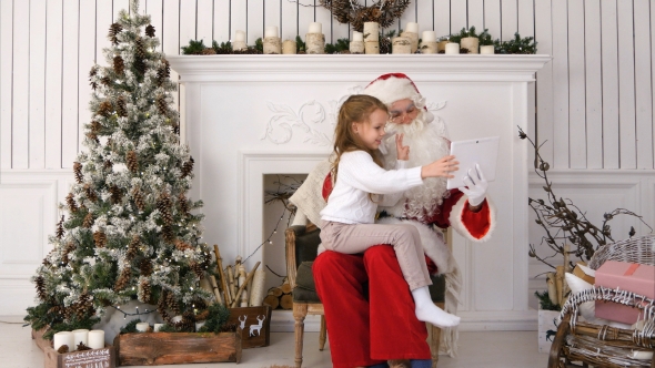 Santa Claus and Cute Little Girl Taking Christmas Selfies on Tablet