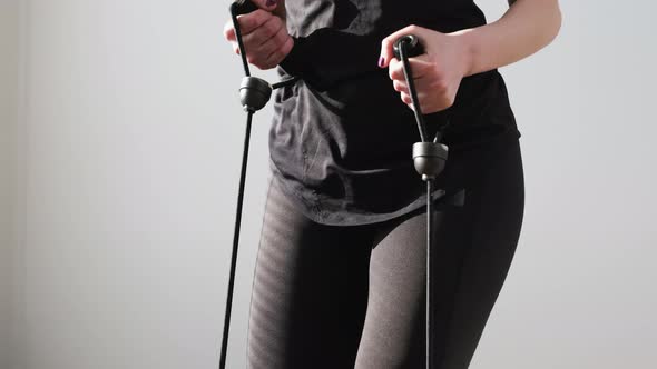 Woman in a Black Sportswear Doing Exercises Using Expander on the Stepper