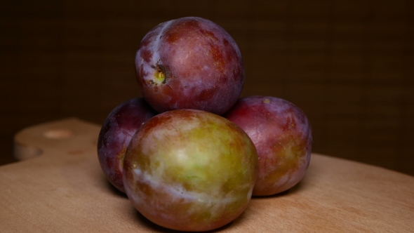 Portion of Plums at Wood Rotating Plate
