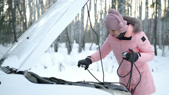 Woman Trying to Fix Discharged Battery of Car