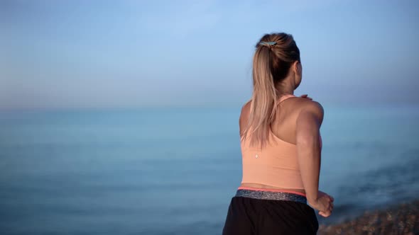 Female Jogger Training at Morning Natural Landscape with Sky and Sea Slowmo