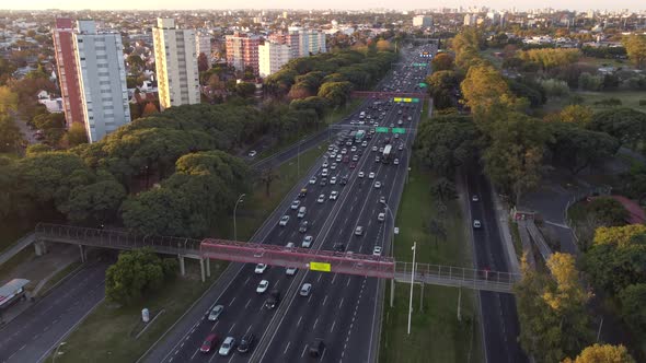 circular drone view of the heavy traffic on the General Paz Highway at sunset around Buenos Aires, A