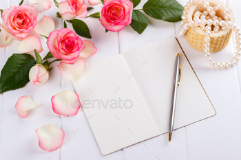 int pen, pink roses and pearls on wooden desk, overhead view romantic concept