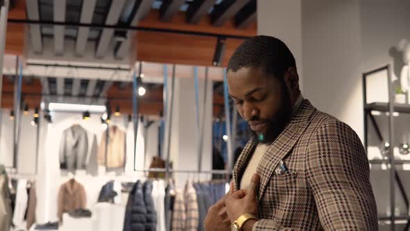 Young Confident Man in Luxury Menswear Boutique Choosing New Suit