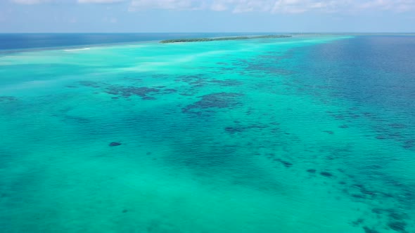 Aerial drone shot panorama of relaxing seashore beach adventure by blue water and bright sand backgr