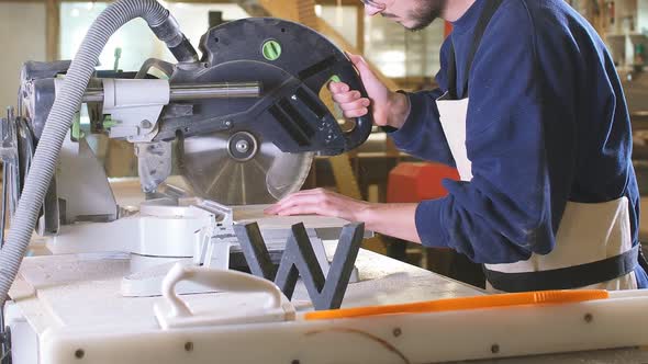 Carpenter Male Using Circular Saw for Cutting Wooden Boards