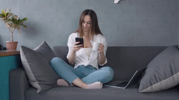 Relaxed Young Woman Using Smart Phone Surfing Social Media Checking News Playing Mobile Games or