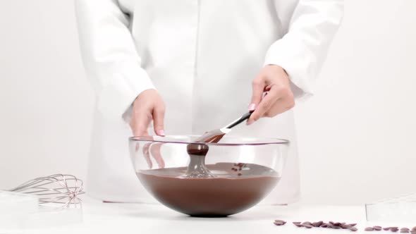 Chef Confectioner Mixing Melted Chocolate in Glass Bowl Slow Mo on White