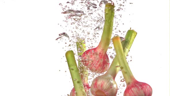 Super Slow Motion Garlic Under Water with Air Bubbles on a White Background