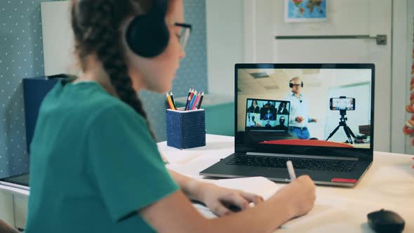 Online Education Concept. Schoolgirl Participating in an Online Call Using Her Laptop