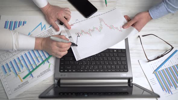 Two businessmen are working in the office, discussing the schedule of market