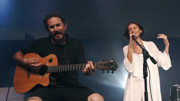 Female Singer and Musician Playing Guitar Performing on Stage