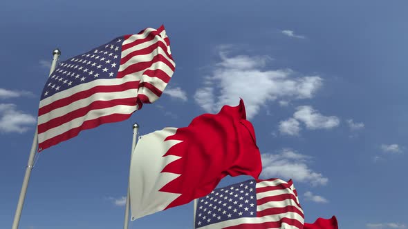 Waving Flags of Bahrain and the USA on Sky Background