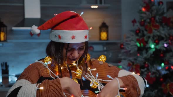 Cheerful Woman Laughing at Tangled Rope with Lights