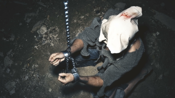 a Prisoner in Chains Is Closed in the Basement Where a Little Light Penetrates