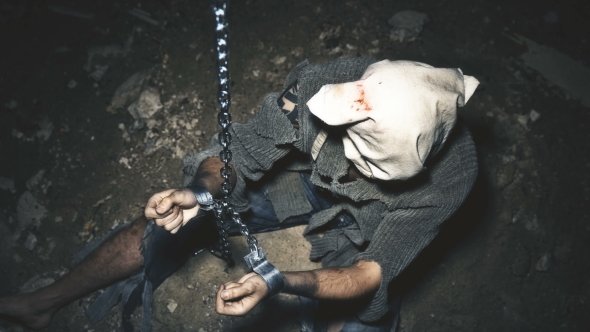 a Prisoner in Chains Is Closed in the Basement Where a Little Light Penetrates