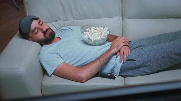 Tired Man Lying on Sofa Watching Movie Show