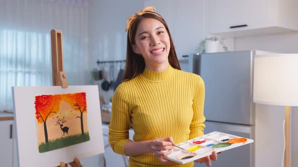 Portrait of Asian young artist girl coloring on painting board at home.