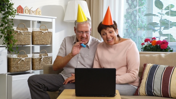 Happy Grandpa and Grandma Congratulate Their Children Happy Birthday Using Laptop Video Call