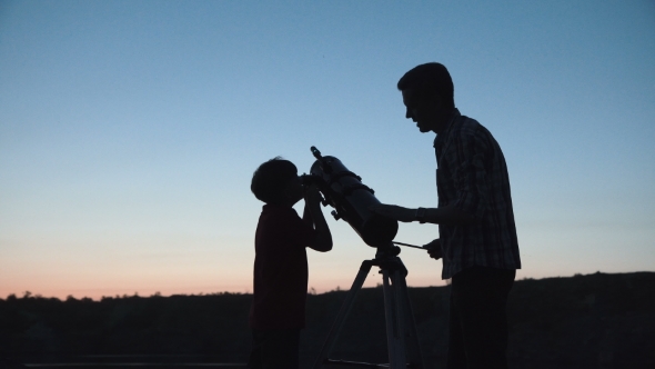 Man and Boy Using Telescope alt