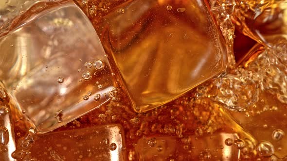 Super Slow Motion Detail Shot of Pouring Cola Lemonade Into Glass with Ice Cubes at 1000 Fps