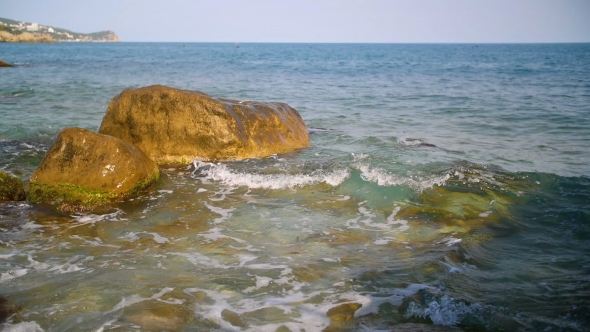 Sea Waves Splashing Against Rocks on Blue Sky