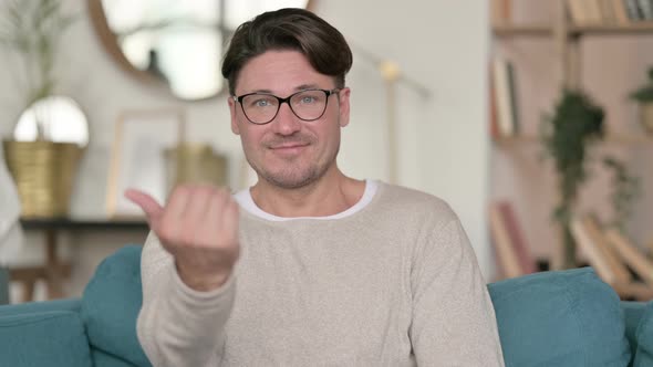 Middle Aged Man Pointing and Inviting at Home 