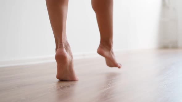 Slim Female Bare Feet Walking White Wall