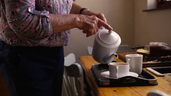 Woman preparing coffee on dining table in kitchen at home 4k