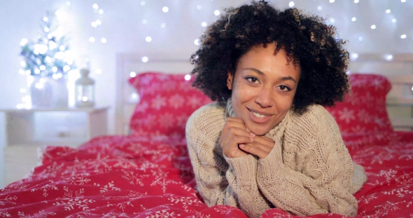 Pretty Young African Woman in a Festive Bedroom