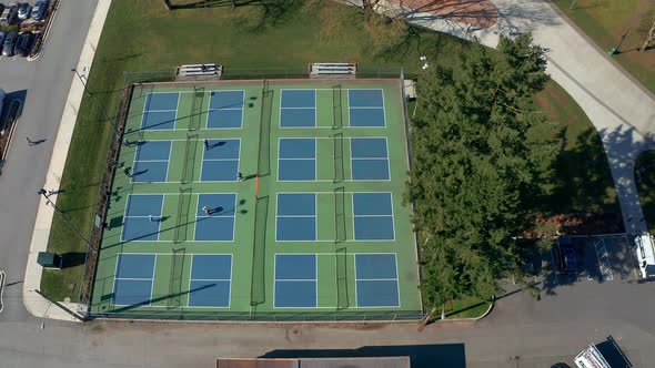 Tennis Players in a City Park, Drone Truck Left past the Sports Courts