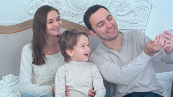 Happy Young Family Taking Selfies on Sofa with Tablet