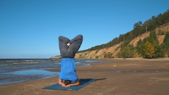 Muscular Handsome Young Man Working Out, Yoga, Pilates, Fitness Training, Doing Handstand, Scorpion