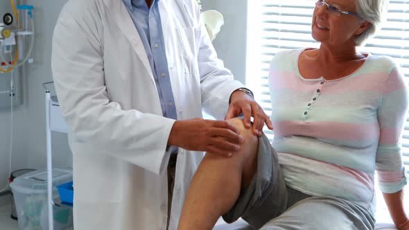 Physiotherapist giving knee therapy to senior woman