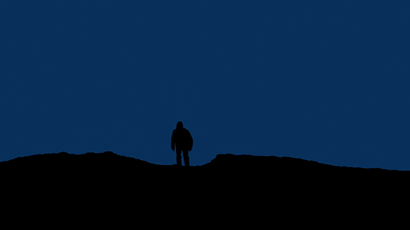 Man Walks Over Hill At Night