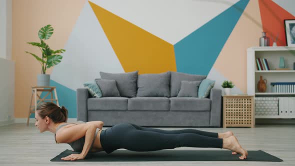 Athletic Lady Exercising at Home in Plank Position Then Doing Yoga Downward Dog Asana