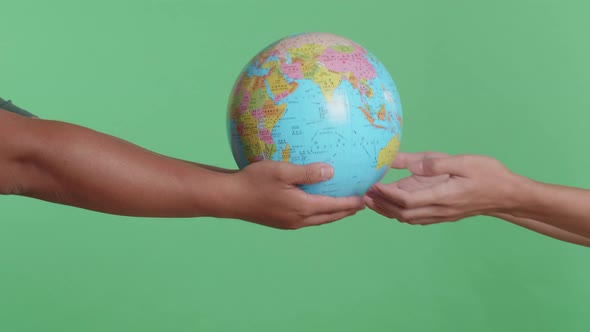 Close Up Of Men'S Hands Hand In The World Globe To Each Other On The Green Screen Background