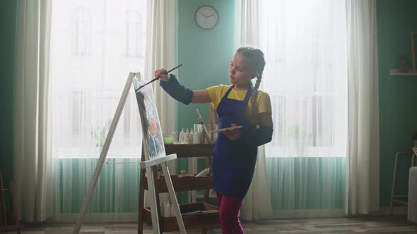 Schoolgirl Is Painting and Looking at Camera