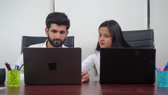 Indian girl helping her colleague in some office work