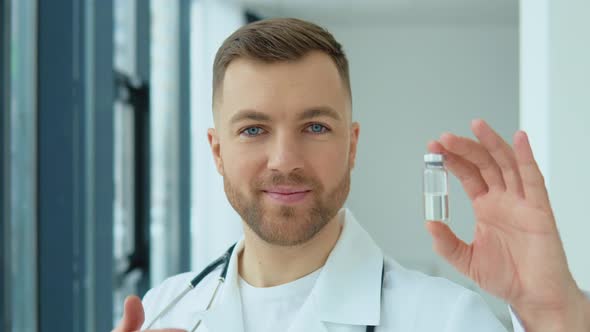 A Doctor Holds an Ampoule with a Vaccine in His Hand