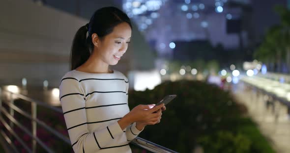 Woman looking at mobile phone at night 