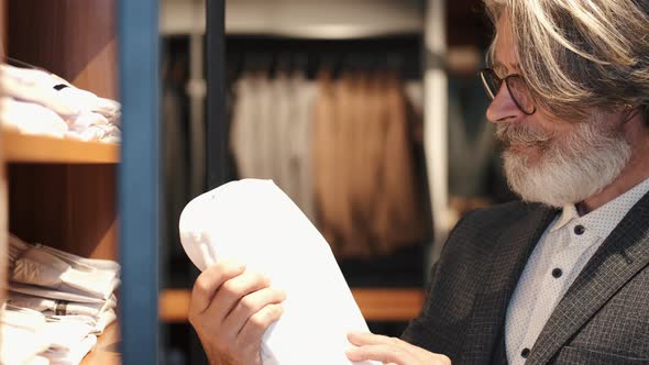 Man Chossing Clothes at Men's Wear Store