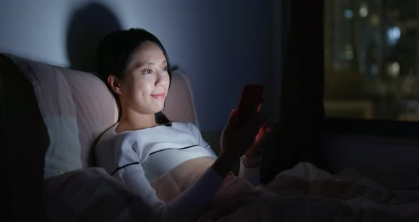 Woman Use of Smart Phone on Bed at Night