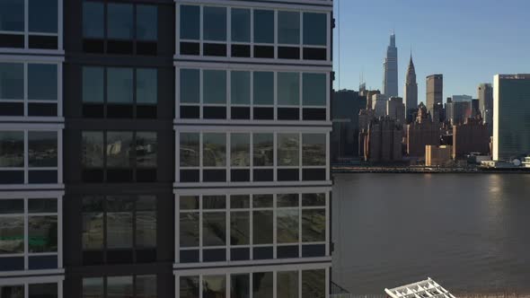 An aerial view from over Queens, NY on a sunny day with blue skies. The drone camera, up close to a