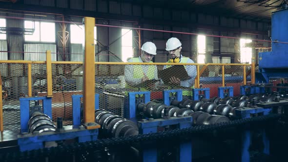 Factory Workers are Inspecting a Reeling Conveyor