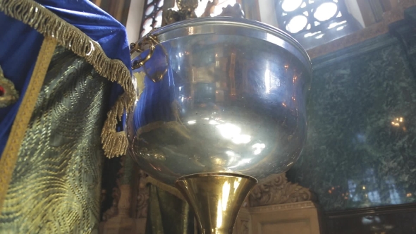 In a Religious Temple a Metal Bowl Is Illuminated By a Sunbeam. alt
